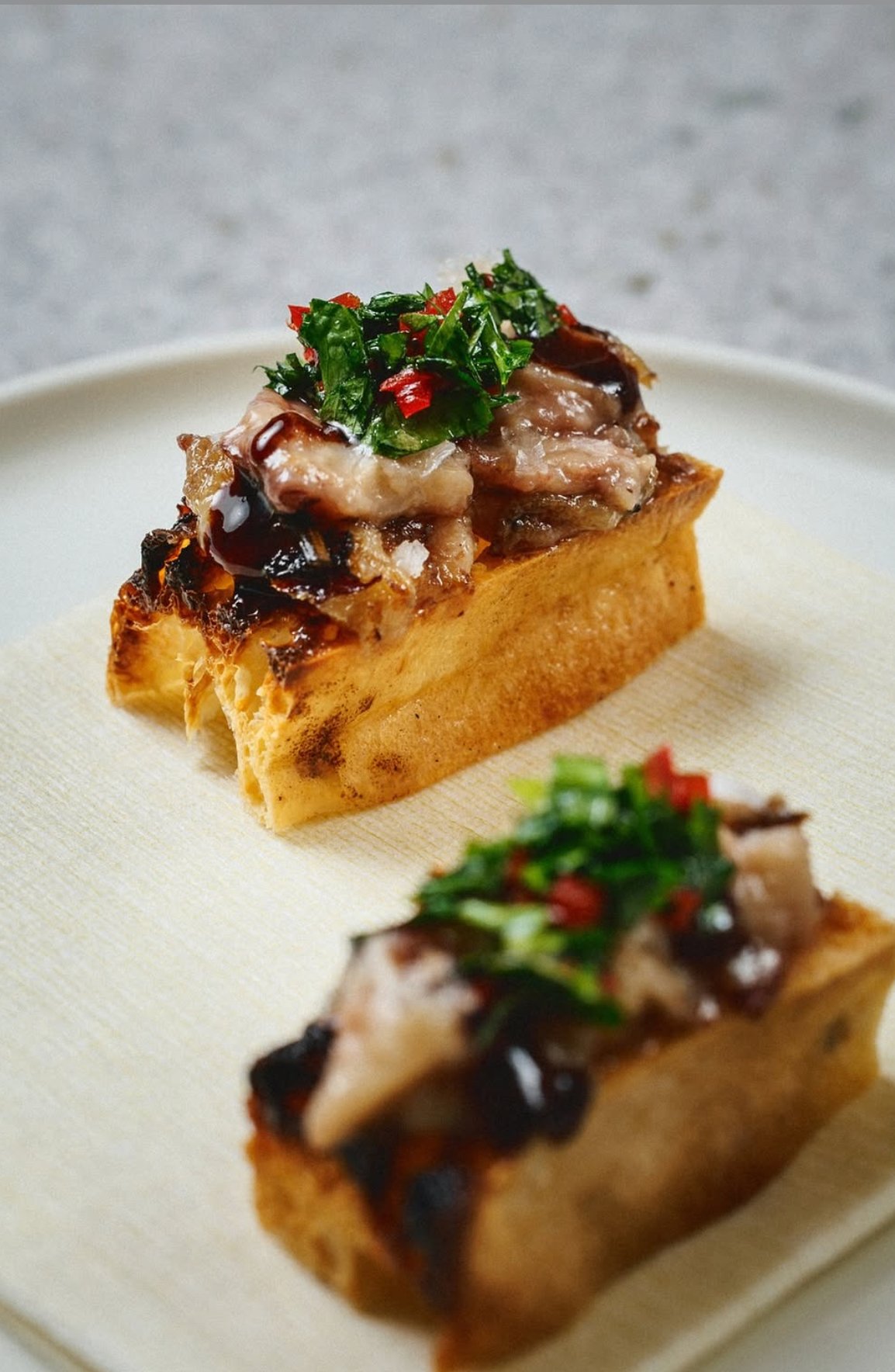 Savoury bread topped with glazed pork and herb relish