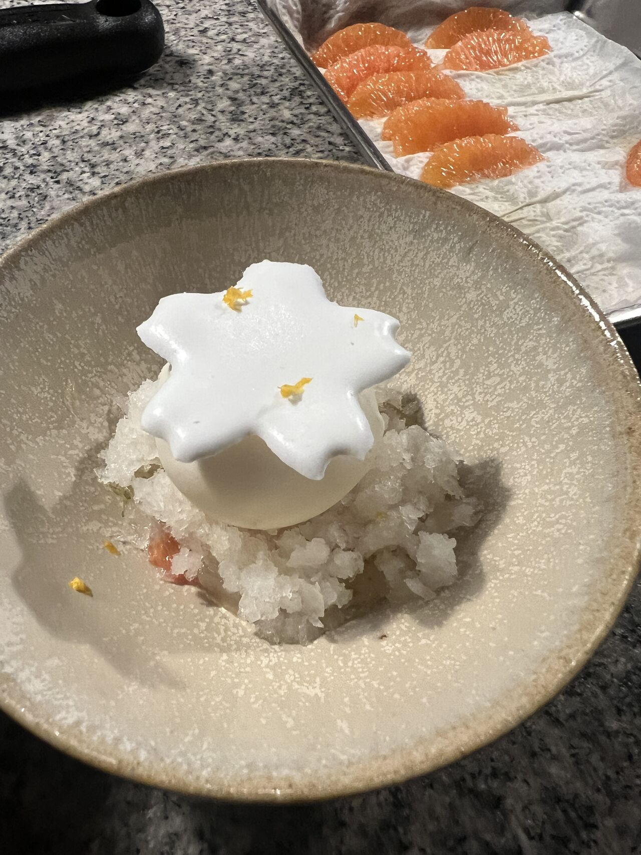 Plated dessert with cream foam over citrus granita